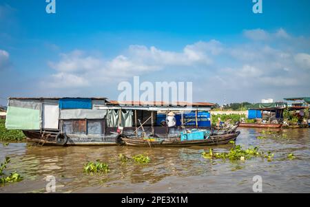 Two women chat on tatty house boats floating on the Mekong river near Long Xuyen in the Mekong Delta, Vietnam. Stock Photo