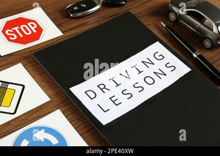 Workbook for driving lessons, pen and road signs on wooden table ...