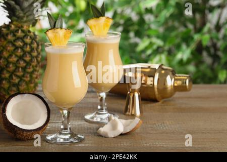 Tasty Pina Colada cocktails and ingredients on wooden table, space for text Stock Photo