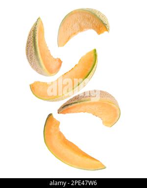 Pieces of delicious ripe melon falling on white background Stock Photo