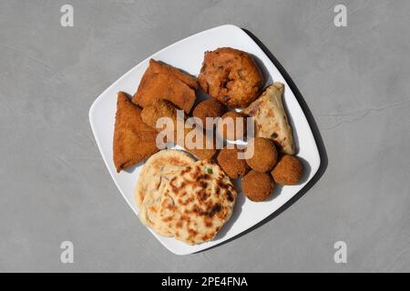 Authentic Sri Lankan different street food, short eats. Vegetable roti, Chinese Rolls , coconut roti, cutlets, mutton rolls on gray background. Snacks Stock Photo