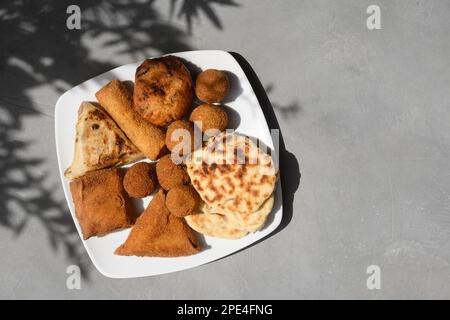Authentic Sri Lankan different street food, short eats. Vegetable roti, Chinese Rolls, coconut roti, cutlets, mutton rolls on gray background. Snacks Stock Photo