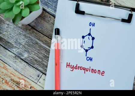 Concept of Hydroquinone write on paperwork, structural chemical formula isolated on Wooden Table. Stock Photo