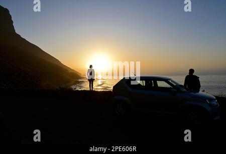 Two people enjoying the sunset at Kogel Bay, Western Cape, South Africa Stock Photo