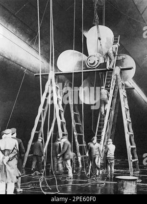 Men working on one of the propellers of the White Star liner RMS Majestic, Southampton, England, 1934. Originally launched in 1914 as the Hamburg America Line liner SS Bismarck, following World War I, she was finished by her German builders and handed over to the allies as war reparations and became the White Star Line flagship RMS Majestic. Stock Photo