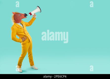Funny businessman with horse head shouting through megaphone Stock Photo