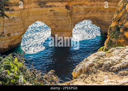 Heart shape made by arches and plants at Marinha Beach in Algarve ...