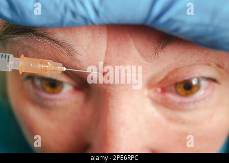 Senior woman getting skin care injection. Aged lady having botox injecting procedure. Cosmetic treatment with injection in a clinic Stock Photo