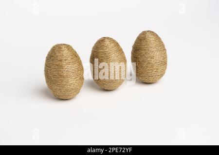 Hand wrapped easter eggs with jute twine, isolated white background. Studio Stock Photo