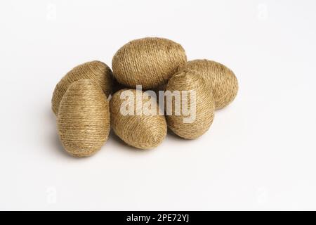 Hand wrapped easter eggs with jute twine, isolated white background. Studio Stock Photo