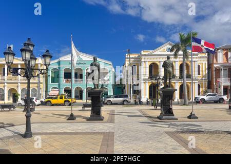 Colonial houses with statues by Juan Pablo Duarte and General Gregorio Luperon in Parque Independenzia in Centro Historico, Old Town of Puerto Plata Stock Photo