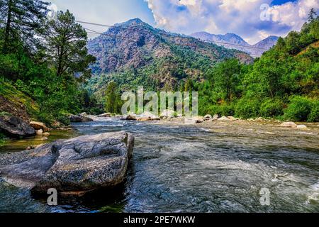 The Tirthan River flowing through the scenic Tirthan Valley in Himachal Pradesh Stock Photo