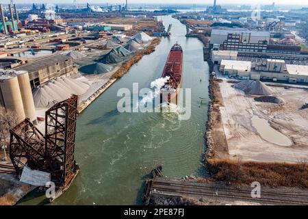 A bulk cargo freighter travels the Rouge River towards the Detroit River along city borders of Detroit and River Rouge, Wayne County, Michigan, USA. Stock Photo