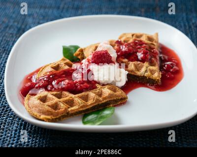 Heart shaped beet waffles with a raspberry sauce Stock Photo