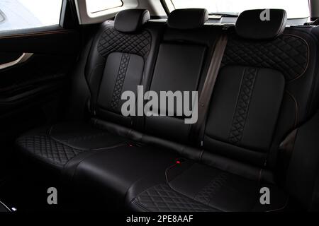 Modern car interior. Clean rear seats with the belts. Three rear seats in the row. Leather back passenger seats. Stock Photo