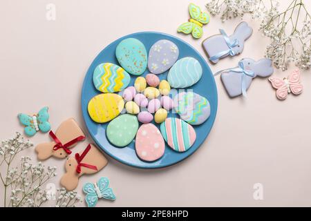 Easter banner on a pastel background. Homemade gingerbread cookies on a blue plate, Easter eggs and cookies in the shape of a rabbit and a butterfly. Stock Photo