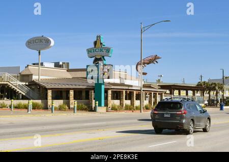 Galveston, Texas, USA - February 2023: Nick's beach bar and kitchen on the city's seafront road with passing traffic Stock Photo