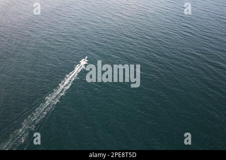 Fishing boat sail on sea water aerial drone view Stock Photo