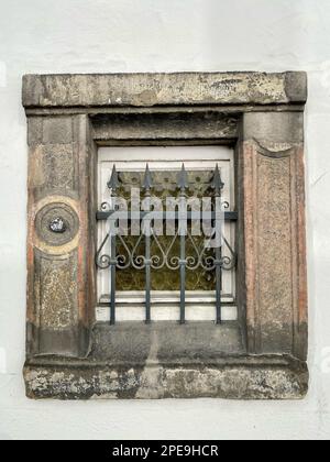 Old window in the historic city wall of Paderborn. The decorated iron bars are supposed to protect against burglary. Stock Photo