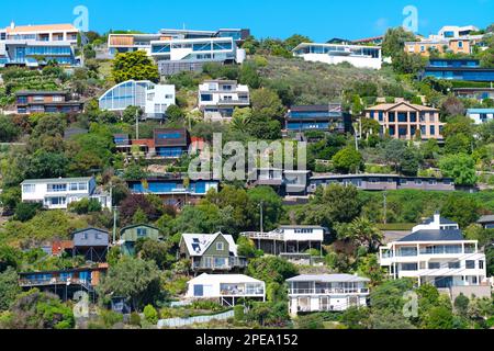 Residential properties on a hillside with a blue sky background,  Sumner, Christchurch, New Zealand. Stock Photo