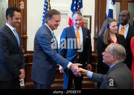 Austin Texas, USA. 15th Mar, 2023: Texas Governor GREG ABBOTT, r, shakes hands with Texas A&M University System Chancellor JOHN SHARP during a press conference with Texas elected officials, educators and business representatives, about the Texas CHIPS Act. The Creating Helpful Incentives to Produce Semiconductors (CHIPS) Act, if passed, would focus on Texas research and development efforts in winning semiconductor chip projects. In the center is University of Texas President JAY HARTZELL. Credit: Bob Daemmrich/Ģ����ý Live News Stock Photo