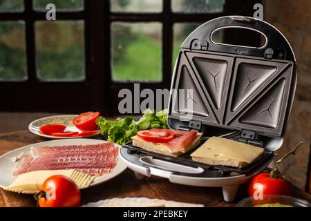 Sandwich maker. Cooking sandwiches with different fillings. Stock Photo