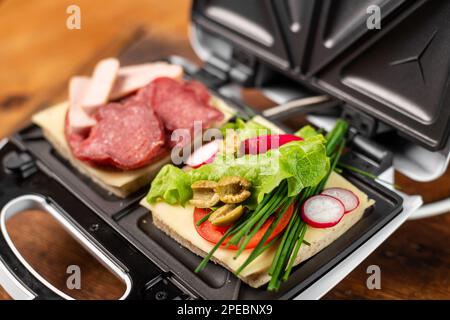 Vegetarian and meat-eating sandwich. Comparison. Sandwich stuffed with meat  sausages and ham against a stuffing of lettuce, onion, olives and tomato  Stock Photo - Alamy