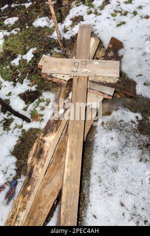 Crosses from graves are seen stuck in the snow. Only crosses and pits remain in the pine forest on the outskirts of Izium, where a mass grave was discovered after the town was liberated by Ukrainian forces. At the end of September, law enforcement officials completed the exhumation. They removed 450 bodies from the graves, mostly civilians. An employee of a local ritual service collected them from around the city and buried them in the woods near the old cemetery. Stock Photo