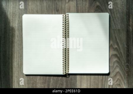 Notepad with blank pages on wooden table. High angle view of open notebook copy space for text. Taking notes concept. Blurry background. Stock Photo