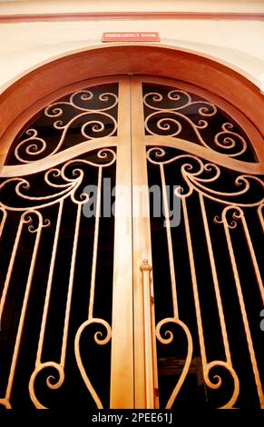 Ornate metal doors of emergency exit with a sign on it. Decorative gate prepared for evacuation in case of fire or another danger Stock Photo