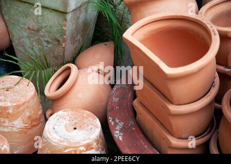 Many assorted ceramic plant pots at the market. A lot of terra cotta clay pots stored outdoors for garden decoration and landscaping Stock Photo