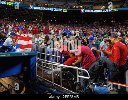 Puerto Rico pitcher Edwin Diaz (39) is being helped by team pitching coach  Ricky Bones and medical staff after the the Pool D game against Dominican  Republic at the World Baseball Classic