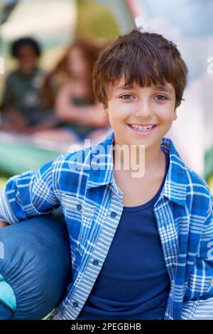 He cant wait for the camp sleepover. A boy standing in front of his campsite. Stock Photo