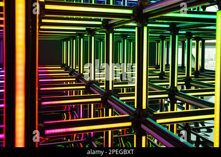 Futuristic neon red yellow green light cube art installation. Technology cyber cube, Sci fi shape. Abstract conceptual background with colorful neon c Stock Photo