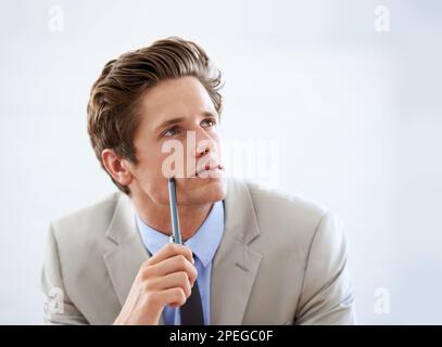 Pondering business strategies. A handsome young businessman looking away thoughtful. Stock Photo