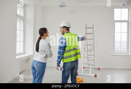 Architect, engineer or foreman talking to a young woman about house construction Stock Photo