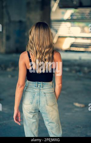 Rear view of woman standing inside a derelict building Stock Photo