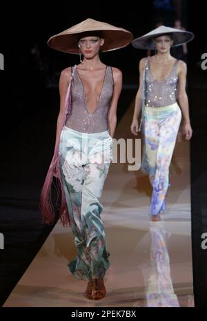 Two models walk the runway in shimmering stretch scoop neck tops with  floral patterned silk Chinese pants during the presentation of Giorgio  Armani's Spring/Summer 2005 collection, Tuesday, Oct. 26, 2004, at Pier 54  in New York. It was Armani's first show ...