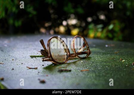 Broken pair of glasses, spectacle frame on concrete, artsy, melancholic, closeup Stock Photo