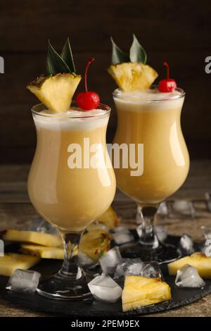 Tasty Pina Colada cocktails on black slate plate Stock Photo