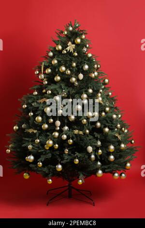 Beautifully decorated Christmas tree on red background Stock Photo