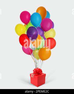 Beautiful gift box and bunch of colorful balloons on white background Stock Photo
