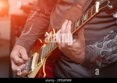 The guitarist plays on guitar. Hands of a Guitar player playing the guitar. Selective focus. Soft focus Stock Photo