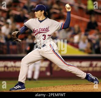 Montreal Expos starting pitcher Scott Downs, left, wipes his forehead as is  teammatesTony Batista, Maicer Izturis and Alex Gonzalez return to play  after the Atlanta Braves scores two runs during third inning