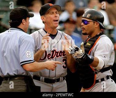 Detroit Tigers pitching coach Bob Cluck, left, reaches out to