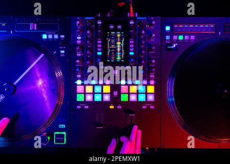 Hands of a DJ creating and regulating music on dj console mixer at club concert Stock Photo
