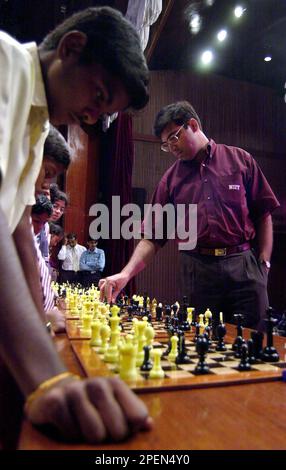 V. P. Kaushik, 11, watches as Indian World Rapid Chess Champion Viswanathan  Anand, unseen right, makes a move at the launch of a school chess  tournament organized by the NIIT Mind Champion's
