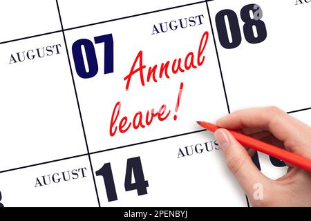 7th day of August. Hand writing the text ANNUAL LEAVE and drawing the sun on the calendar date August 7. Save the date. Time for the holidays. vacatio Stock Photo