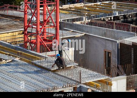 Workers prepare reinforcement for reinforced concrete at a construction ...