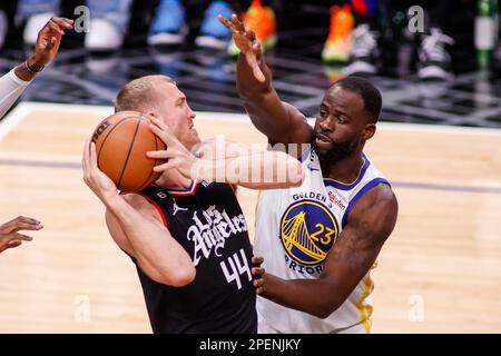 Los Angeles, United States. 15th Mar, 2023. Los Angeles Clippers forward Mason Plemlee (L) is defended by Golden State Warriors forward Draymond Green (R) during an NBA basketball game at Crypto.com Arena in Los Angeles. Credit: SOPA Images Limited/Alamy Live News Stock Photo